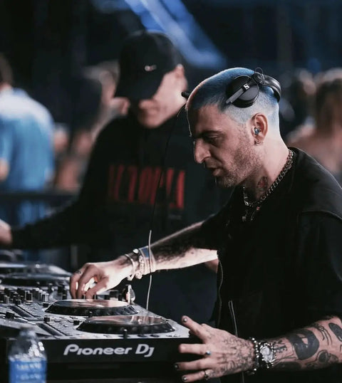 DJ wearing high fidelity reusable earplugs with blue filters for concerts and live music offering superior noise reduction hearing protection