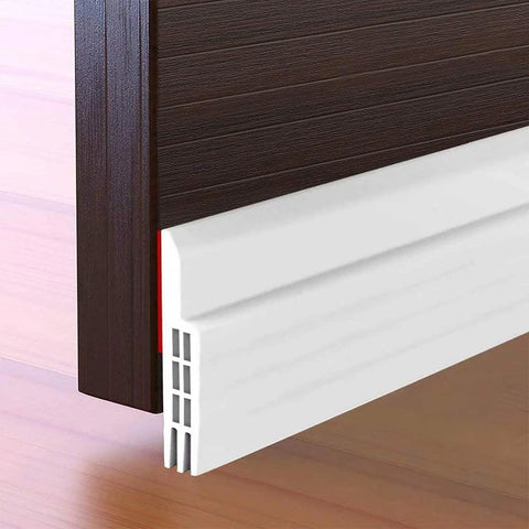 White plastic door draft stopper under door sweep, 2 in W x 39 in L, attached to bottom of dark wood door.