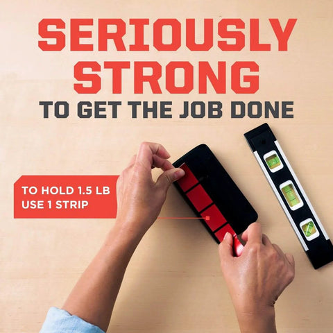Hands applying Extreme Double Sided Mounting Strips Mega Pack 1 Inch By 3 Inch Tape Holds Up To 30 Lbs Indoor Or Outdoor Use 48 Strips