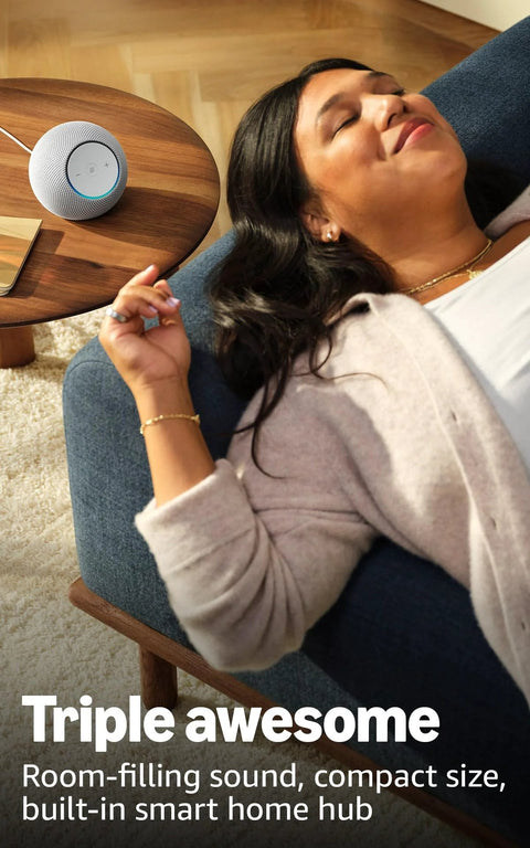 Woman relaxing on sofa with Echo Dot Max Graphite Finish on table, delivering room-filling sound and built-in smart home hub.