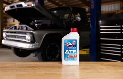 Economical ATF Type A Automatic Transmission Fluid 1 Quart bottle on workbench, budget friendly, anti foam additive, red dye leak detector.