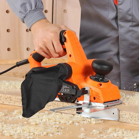 Effortlessly smooths stock, edges, and chamfers with a 7 Amp corded electric hand planer, featuring a 3 and 1 quarter inch cut width, 16800 RPM, adjustable depth, and dual blades for precise removal and a durable professional finish. Image shows a hand holding an orange electric hand planer on wood.