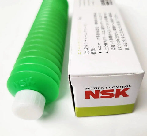 Excella Green NS7 Low Torque Synthetic Grease tube next to NSK branded box, ideal for high speed linear guides and ball screws.