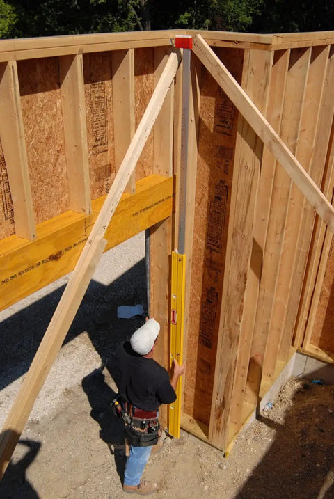 Extendable Plate Level for 6 to 10 Feet with Removable Standoffs and Extra Long Spirit Level in use on tall wooden wall frame