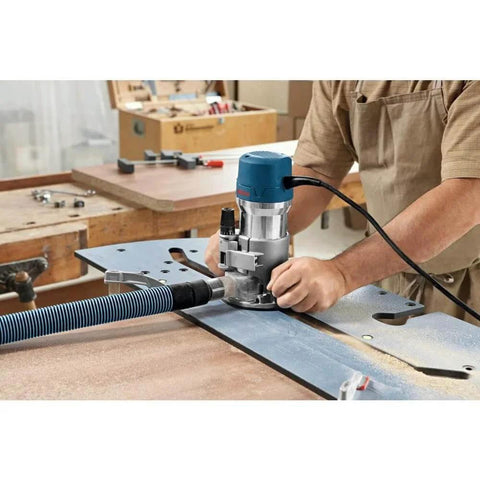 Person using Fixed Base Router 2.25 HP 12 Amp Variable Speed 8000 to 25000 RPM for precise edge work on wood panel.