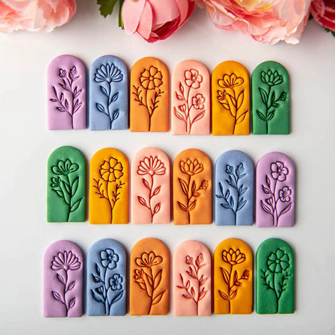Colorful clay impressions made with 7 Piece Soft Clay Leaf Cutter Mold Set For Flower Stamps And Floral Earrings Making Tools Jewelry Craft Kit For DIY Artists Plastic Jewelry Molds For Flawless Impressions And Creative Workshops, featuring detailed floral designs on clay slabs.