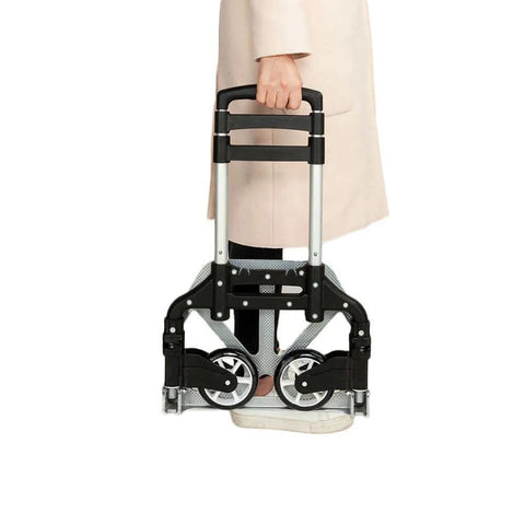 Person holding a ✝️ Folding Hand Truck Aluminum Portable Folding Hand Cart 165lbs Capacity Hand Cart and Dolly Ideal for Home, Auto, Office, Travel Use, Black, folded and compact