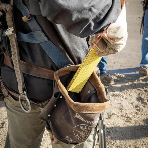 Worker using Folding Ruler 6-Foot Fiberglass With Brick Scale On Reverse And Outside Reading One Sixteenth Inch Graduation Riveted Lock Joints in field.
