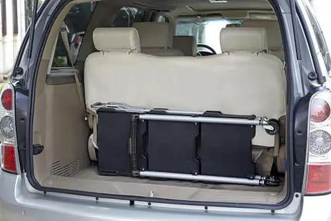 Pack N Roll Folding Collapsible Service Cart With 150 Lb Capacity, folded in the back of a vehicle, showcasing portability.