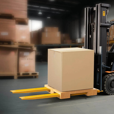 84-inch forklift extensions 4.5 inch wide on forks, lifting a large cardboard box in a warehouse. Built from Q235 carbon steel.