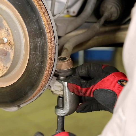Mechanic using 26554 Front End Service Kit, Pitman Arm Puller & Ball Joint Separator on vehicle suspension