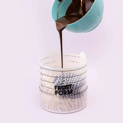 Pouring chocolate into 6 Inch Frost Form Starter Kit For Cake Decorating 7 Piece Set With Liner Form Base Stand Crumb Cutter Finisher