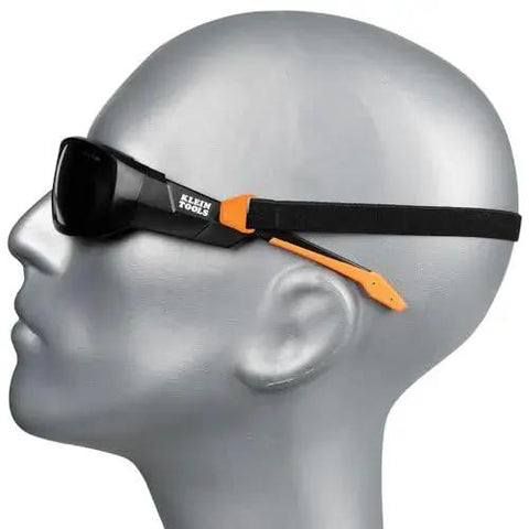 Side view of mannequin wearing full frame gasket safety glasses with foam seal, anti-fog and UV scratch-resistant, with nylon strap.