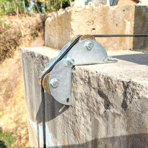 Installed pulley hoist on concrete edge, showing galvanized steel and rope, part of tackle pulley system for lifting with rope.