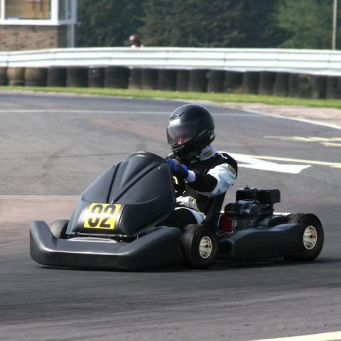 Racer in go kart on track, equipped with Go Kart Tires and Rims, 11x6-5" Go Kart Wheels, 2-Pack Rear Wheels.