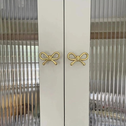 2 Pack Solid Brass Bow Drawer Knobs In Gold on cabinet doors showcasing elegant bow style