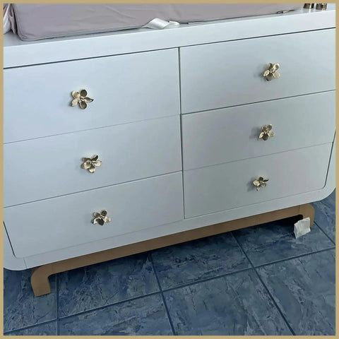 Six Pack 2.4 Inch Gold Flower Cabinet Knobs Set on white dresser showcasing vintage floral petal pulls.
