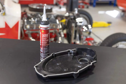 RTV High Performance Silicone Sealant Gray 190 Ml For Flexible Gaskets And High Torque Applications With Heavy Duty Performance And Superior Oil Resistance Low Odor Noncorrosive Formula next to an engine cover