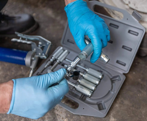 Person assembling Versatile Grease Lubrication Adapter Kit with 12 Inch Hose and Quick Connect Couplings in case
