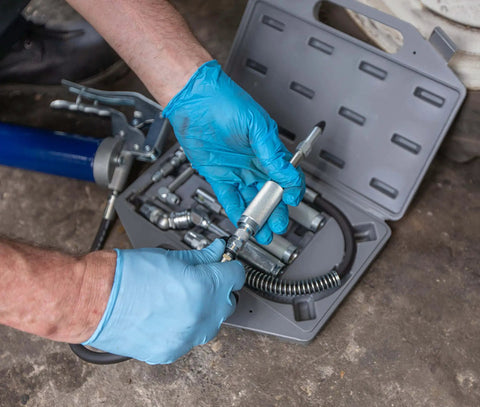 Mechanic using Versatile Grease Lubrication Adapter Kit With 12 Inch Hose And Quick Connect Couplings, Rubber Tip And Needle Nozzles