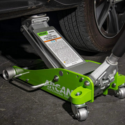 Green 3-Ton Hybrid Aluminum And Steel Low Profile Floor Jack With Dual Pump Pistons in use lifting a vehicle