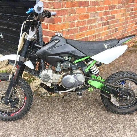 Rear Shock For Dirty Pit Bike With Adjustable Rebound And Dual Spring Options 250lb Or 350lb mounted on black and green bike