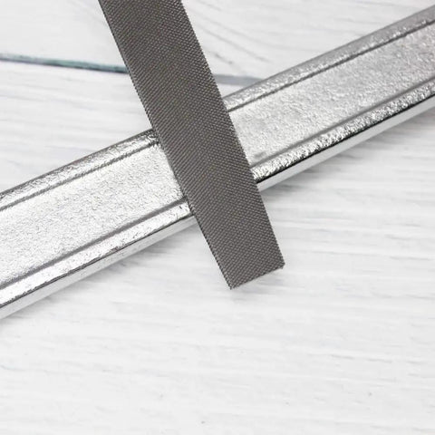 Flat Hand File With Double Cut Teeth For Wood And Metal In High Carbon Steel, showing textured teeth on flat metal.