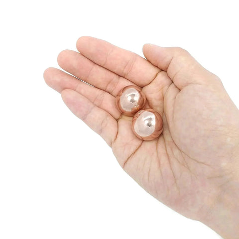 1 inch Solid Copper Baoding Balls with Carry Pouch for Hand Therapy, Exercise, and Stress Relief shown in hand for size comparison