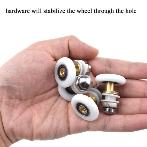 Hand holding 27mm diameter brass shower door wheels with nylon rollers, stainless steel screws and ball bearings