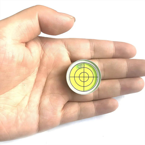 Compact 1.2 inch bullseye bubble level with aluminum alloy housing held in hand, showing green target design with 30 ft / 2 mm precision