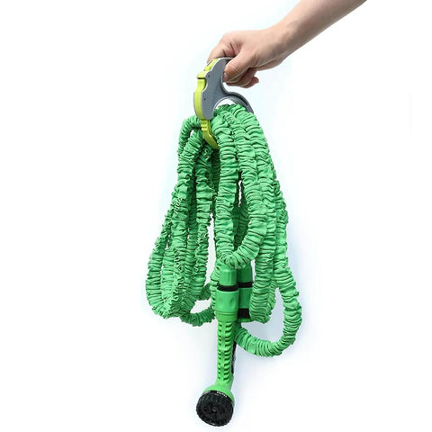 Person holding green expandable garden hose with nozzle, using Spring Ratchet Cable And Hose Clamp Organizer With Spring Loaded Wrap System