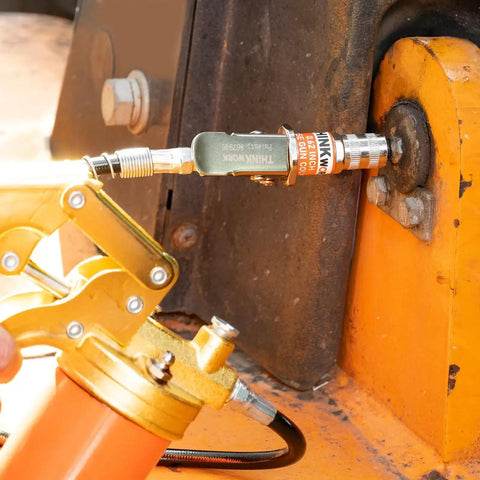 Hands Free Lock On Grease Gun Coupler With Cleaning Tool, 14000 PSI Quick Release, 1/8 NPT fitting attached to machinery