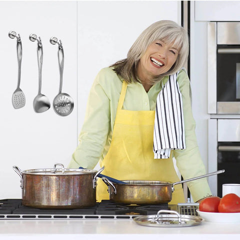 Woman cooking in kitchen with stainless steel utensils and pots on the stove