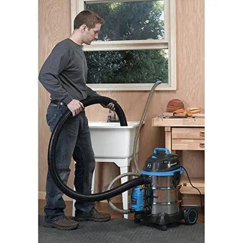 Person using Heavy-Duty Wet/Dry Vacuum Pump Accessory PE401 with drain attachment pumping water at sink in workshop.