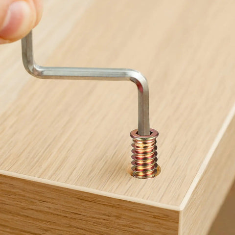 Inserting a metric threaded wood insert into wood surface using hex key from 200 Piece Metric Threaded Wood Inserts Kit M4 M5 M6 M8 M10 With Flanged Hex Socket Drive For Quick Furniture Fix And DIY Woodworking Projects Zinc Plated Finish For Extra Grip And Long Lasting Strength In Cabinets Shelves And DIY Builds