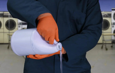 Person pouring liquid wearing Hi Vis Orange Nitrile Gloves Raised Diamond Texture 8 Mil Large Box Of 50