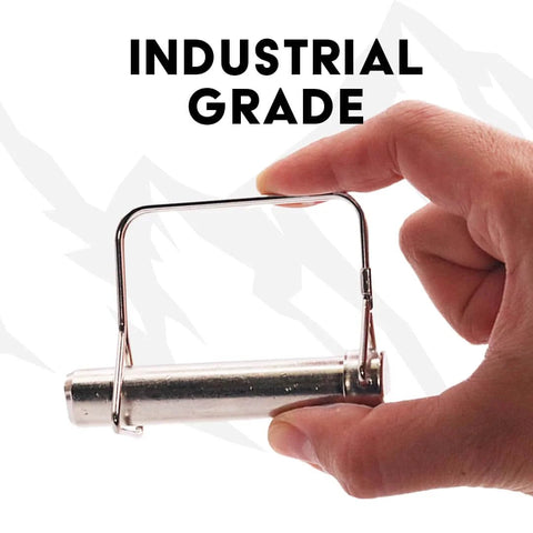 Hand holding a single pin from Beefy 5/8 Inch Square Trailer Pin Set, 3 Inch Long, Six Pack Of Lock Pins For Trailer Hitches.