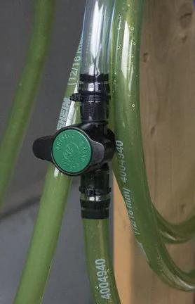 Habitech inline barbed ball valve for 3/4 inch tubing; black body with green knob on green irrigation tubing