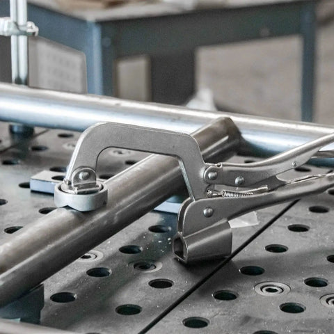 Heavy Duty Five Eighths Inch Insert Table Mounted Clamp With Rear Crank Handle For BuildPro Welding Tables in use on metal pipe