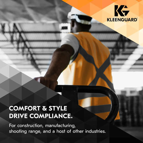 Worker in safety vest holding railing in an industrial facility, promoting protection gear from KleenGuard.