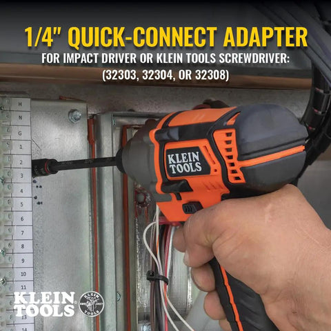 Klein Tools 1/4" Quick-Connect Adapter being used with an impact driver on a control panel. Visible hand holding the tool.