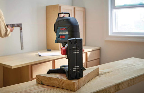 Clear room layout fast with a 360 degree three plane laser delivering bright alignment lines, shown on a wooden table.