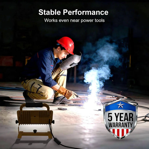 Bright 6500LM LED Work Light With Stand, 500W Equivalent Flood Light illuminating a workshop with a welder, IP67 Waterproof shown