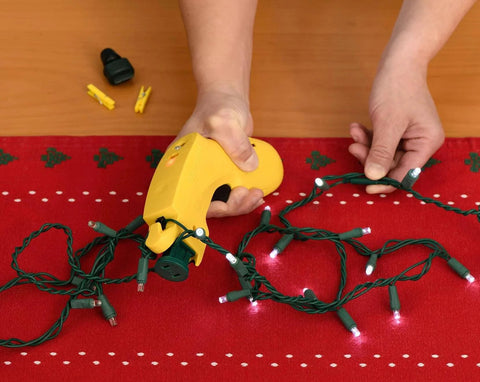 Person using LightKeeper Pro & LED Keeper Pro Combo Pack to repair holiday lights on a red cloth surface.