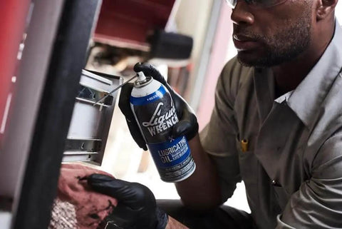 Person applying Heavy Duty Lubricating Oil For Tools And Machinery 11 Oz Keeps Moving Parts Slick Quiet And Rust Free from Liquid Wrench.