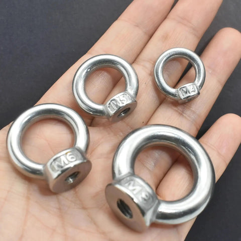 Four M3 stainless steel lifting eye nuts with shoulder ring for rigging and lifting on a hand, focus on metric thread M3 design.