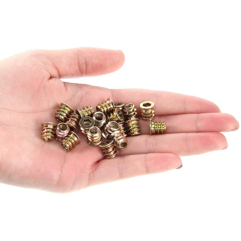 Hand holding 20 Pack M5x10mm Threaded Wood Inserts With Hex Drive Carbon Steel Furniture Nuts for Built to Last Joints