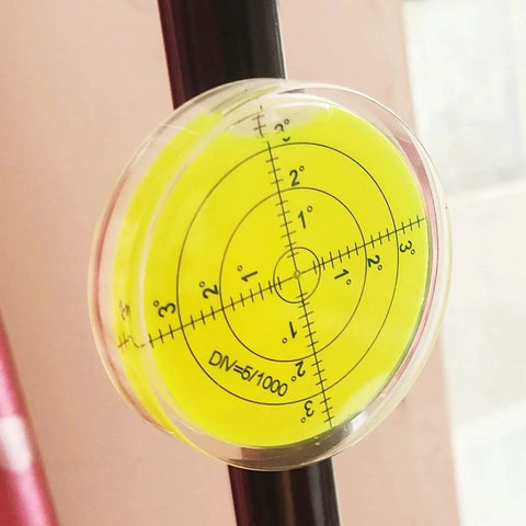 Magnetic Round Bubble Level Tool Pro Grade Bullseye Inclinometer for Machinists and DIY Enthusiasts attached to a metal rod.