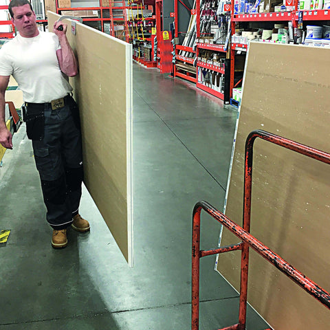 Worker carrying plywood using the JawClaw Panel Gripper for Plywood, Drywall and Steel Sheets, ensuring smooth motion and alignment.