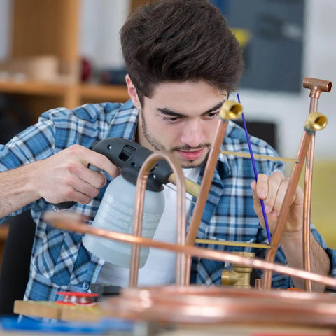Man using AWS BAg7 Silver Brazing Rods Flux Coated Solder Kit Pro Grade for copper pipe repair, focused on brazing process